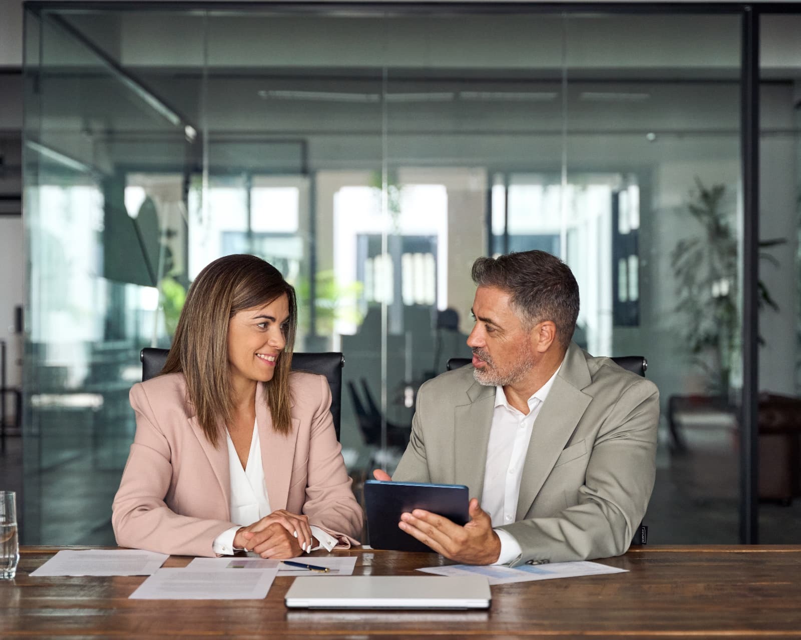 Business consultant and client reviewing documents together at a conference table